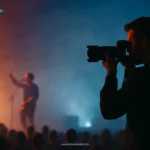 Seorang fotografer konser sedang memotret musisi dengan cahaya dramatis, menggambarkan cara menjadi fotografer konser.